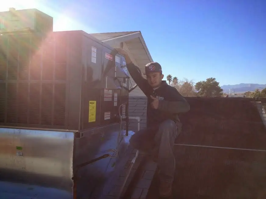 HVAC technician performing HVAC Inspection on a rooftop unit in Harrison